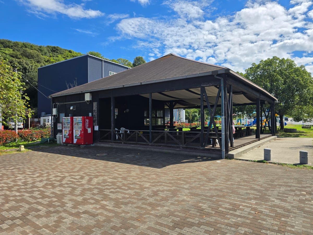 因島アメニティ公園の交流棟（屋根付きテーブル席と自販機2台）