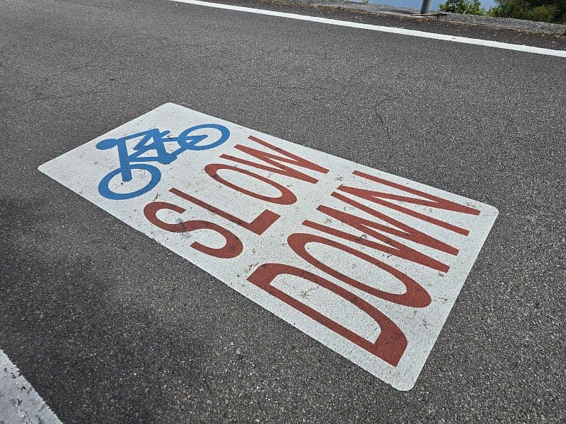 亀老山展望公園からの下り坂に描かれた路面ペイント「SLOW DOWN」（自転車マーク付き）
