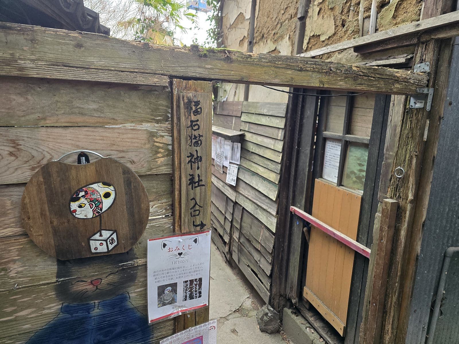 福石猫神社入口の看板——猫の形のロゴと手作りの案内板