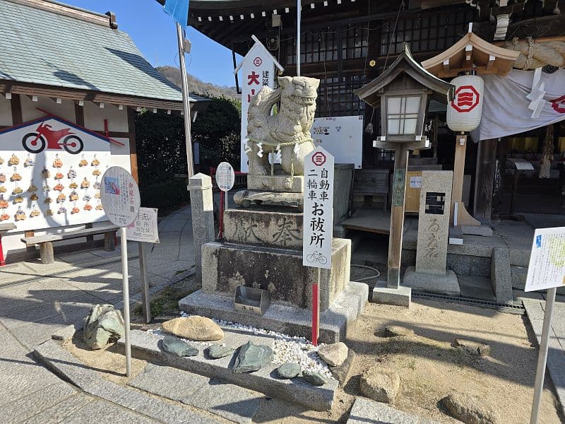 自転車・二輪車お祓い所の石碑。左には自転車の絵馬がびっしりと並ぶ