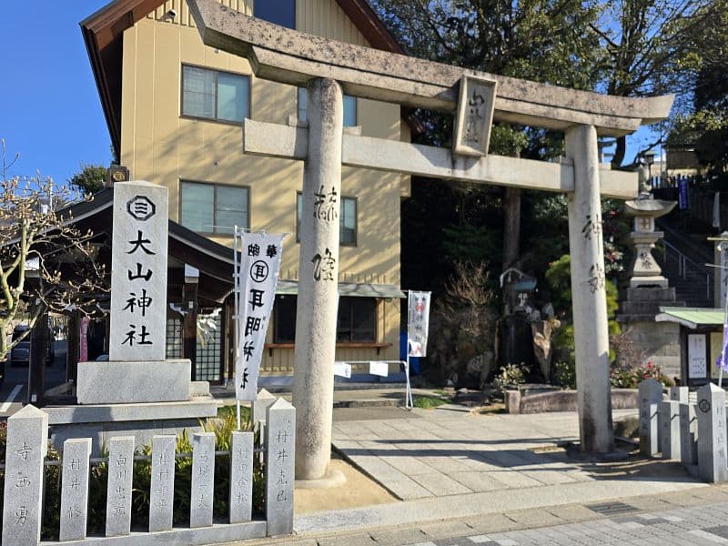 因島大山神社の鳥居と社号標。青空のもと石造りの鳥居が立つ入口