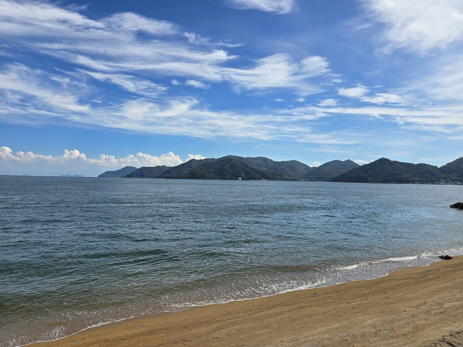 夏の立花の海岸。青空と緑の山々を背景に広がる瀬戸内海