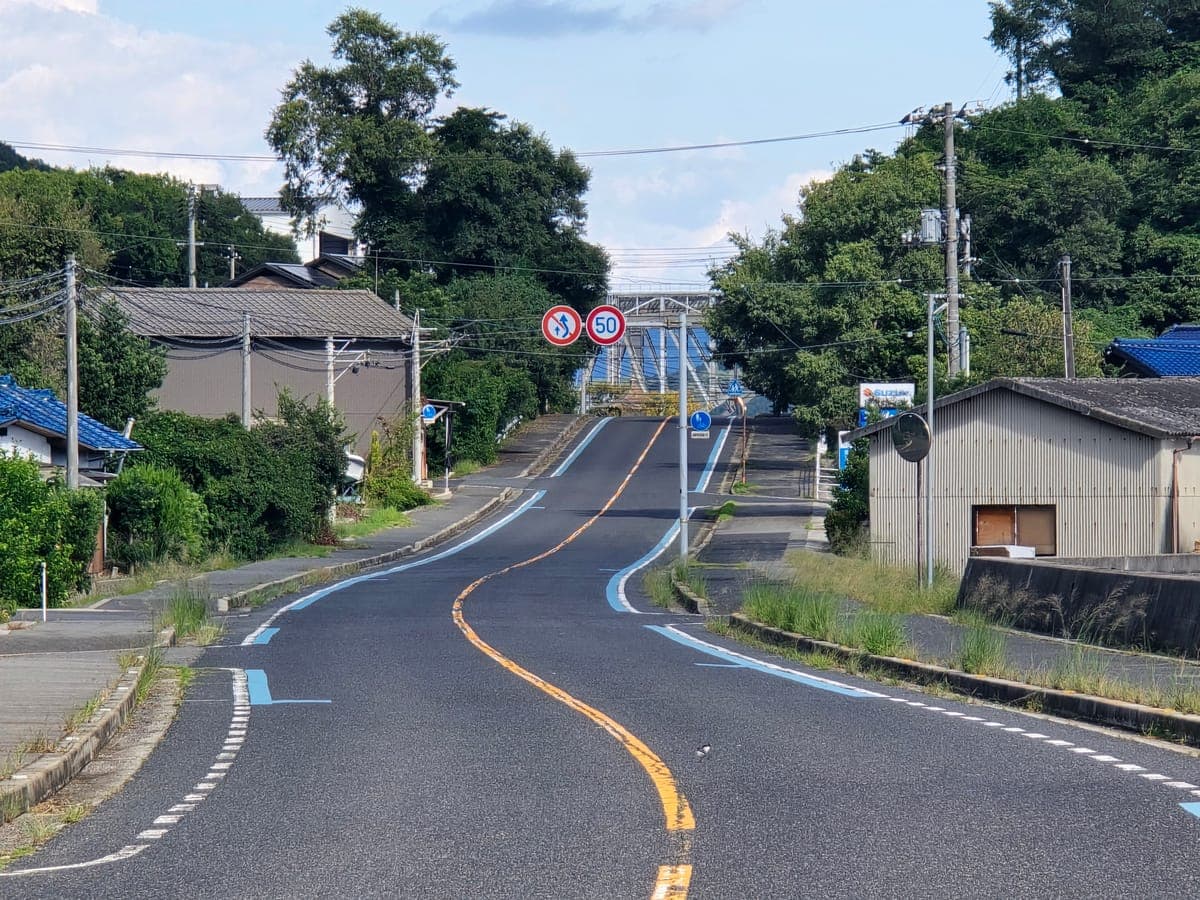生口島の南岸の道を望遠で撮影(約700m先までS字カーブと起伏が続く)