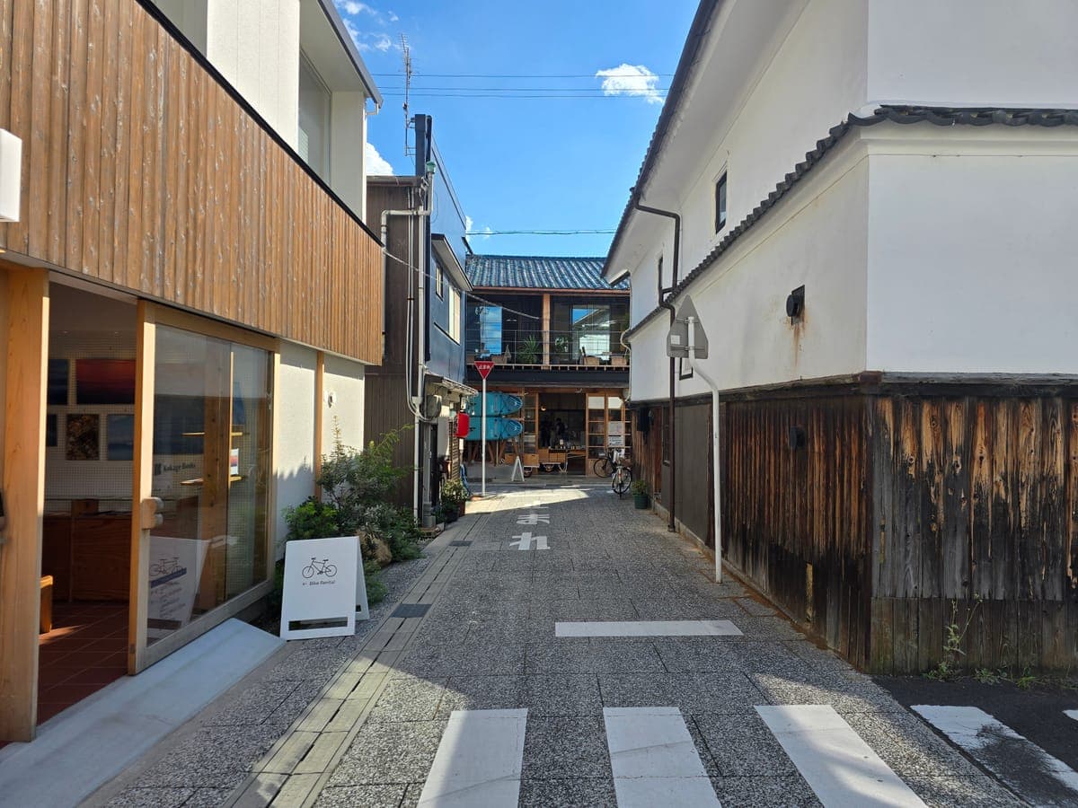 瀬戸田の路地にあるKokage Books(ガラス張りの建物)と白壁の土蔵